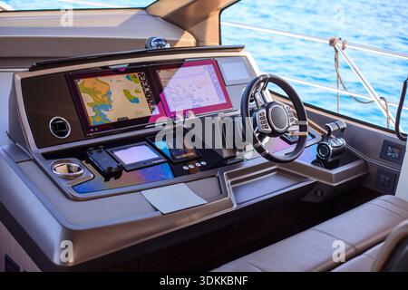 The dashboard of a boat has a large screen with a map on it Stock Photo