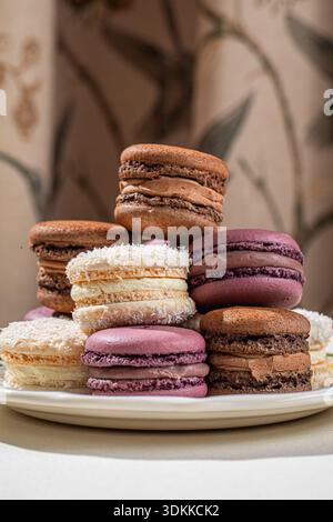Assorted macarons stacked on decorative plate Stock Photo