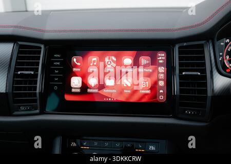Close up of Apple CarPlay infotainment system displayed on a modern car dashboard showing navigation music and messages enabling connected driving con Stock Photo