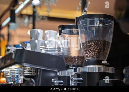 Coffee bean in coffee machine in coffee shop. Coffee shop equipment. Coffee maker and coffee grinder in coffee shop. Stock Photo