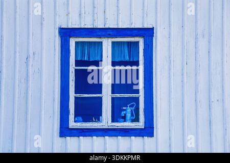 Blue window on white wooden cottage Stock Photo