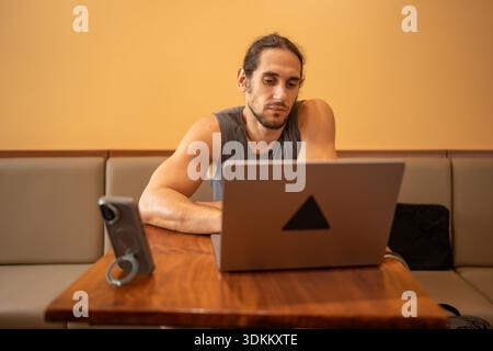 Man concentrating, working remotely on laptop at cafe Stock Photo