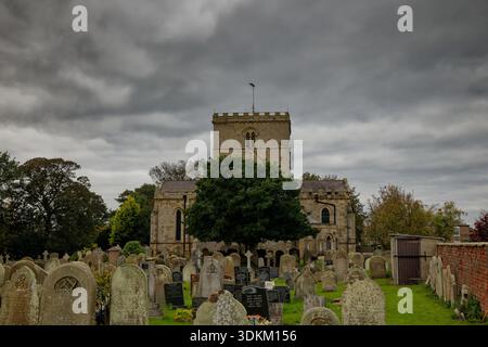 A gloomy atmospheric day in the churchyard of the medieval parish church at Filey, North Yorkshire, England. Stock Photo