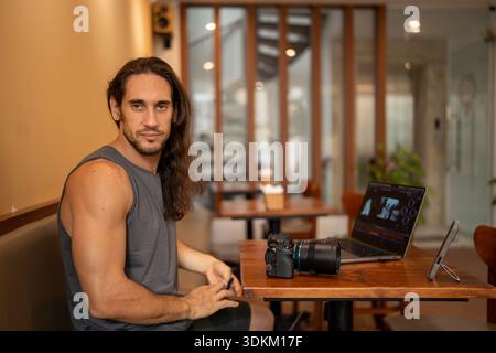 Creative freelancer man editing video content in cafe Stock Photo