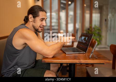Freelancer man working video editing on laptop in cafe Stock Photo