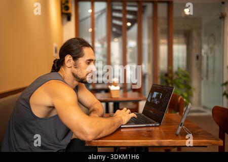 Man working on laptop, editing video in cafe Stock Photo