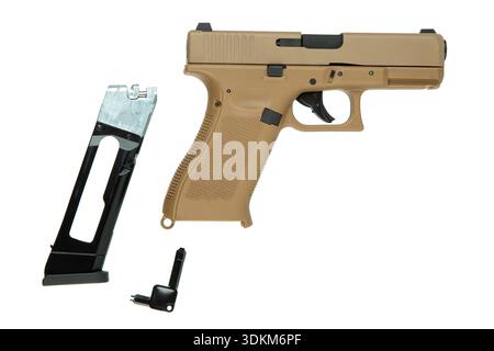 Desert tan pneumatic air pistol with magazine and tool on white background. Stock Photo