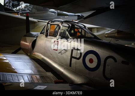 A silver airplane with the letters POC on the side. The airplane is parked in a hangar Stock Photo