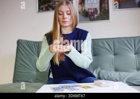 Woman shares tarot card reading with artificial intelligence using smartphone Stock Photo