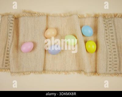Easter holiday background. Colorful plastic eggs are placed on a textured fabric background Stock Photo