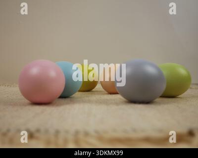 Easter holiday background. Pastel-colored eggs are placed on a textured surface with a neutral background Stock Photo