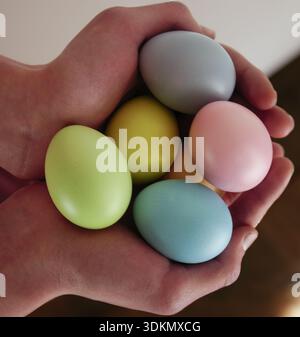 Easter holiday background. Hands grasp a collection of pastel-colored eggs in various shades Stock Photo