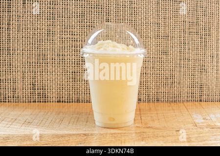 a glass pitcher filled to the brim with pale yellow lemonade, where thin slices of citrus and fresh mint float among the ice that sparkles in the sun. Stock Photo