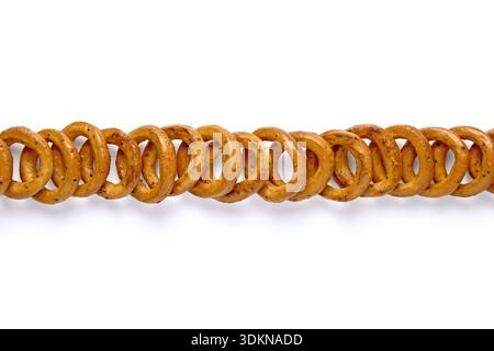 Salted pretzels with poppy seeds lined up in a row isolated on white background. Stock Photo