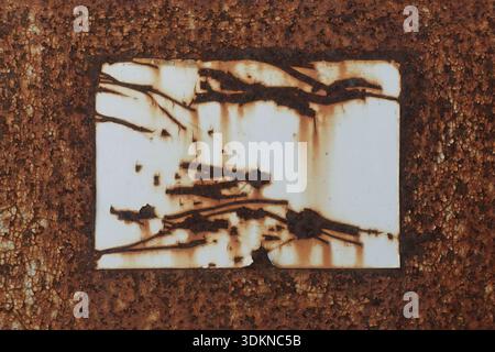 Scratched white label on rusty metal. Grunge background texture with copy space. Stock Photo