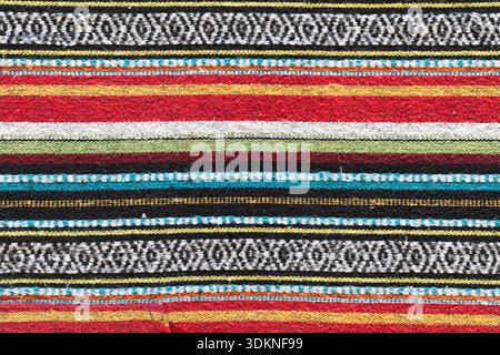 Nepalise or mexican tribal style woollen blanket pattern. Colourful lines of red, blue, yellow and black. Horizontal lines texture woven from brushed Stock Photo