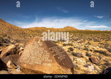 Joshua Tree National Park Large rock with a message written on it. The message is about the importance of work and how it can bring happiness. The ima Stock Photo