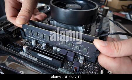 Sarajevo, Bosnia and Herzegovina – January 25, 2026: RAM memory module being installed into a motherboard during desktop computer assembly, amid incre Stock Photo