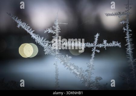 Ice crystals, close-up of frost on glass with bokeh through lights in the background, wintry atmosphere, Finland Stock Photo