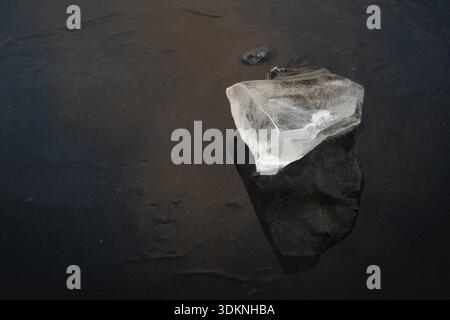 Piece of ice lies on the frozen surface of a lake, Finland Stock Photo