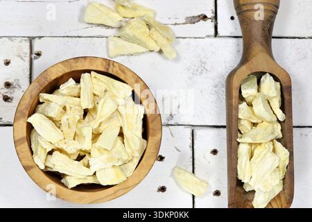freeze-dried pineapple in olive wood tableware on rustic wooden background Stock Photo