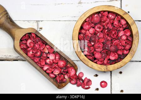 freeze-dried cranberries in olive wood tableware on rustic wooden background Stock Photo