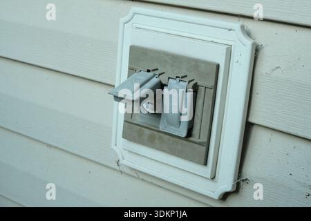 Electrical outlets with protective covers in the backyard of the house. Stock Photo
