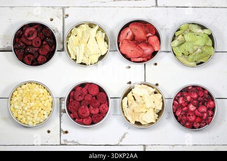 selection of freeze-dried fruits (sour cherries, pineapple, strawberries, kiwi, mango, raspberries, melon, cranberries) in aluminum bowls Stock Photo