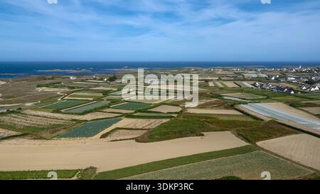 Wide fields stretch toward the distant coastline beneath a clear blue sky and calm horizon. Stock Photo