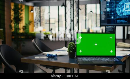 Green screen laptop in empty office used to accelerate complex artificial intelligence calculations. Close up of mockup notebook used for deep learning training datasets systems, camera A Stock Photo