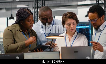 Portrait of smiling engineering team in office working with software development programming languages. Happy startup company coworkers using devices to do code testing and quality assurance, camera B Stock Photo