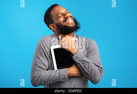 Smiling african american guy holding digital tablet Stock Photo