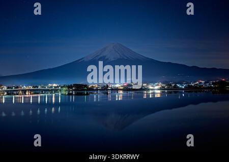 Mt Fuji in Japan, night view under clear starry sky, seen from across lake Kawaguchi, with reflection Stock Photo