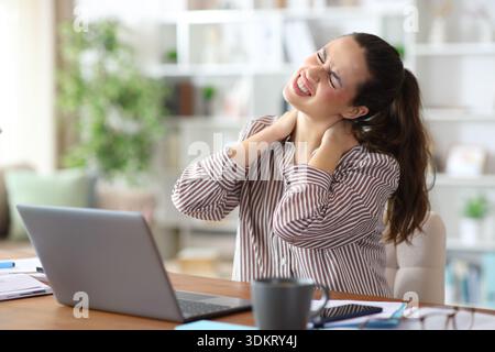 Freelancer woman complaining suffering neck ache working at home Stock Photo