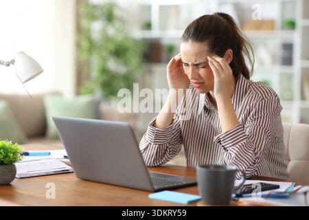 Self employed working and complaining suffering migraine at home Stock Photo