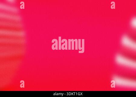 A grainy and blurry abstract background texture featuring a gradient of pink and red colors. Stock Photo
