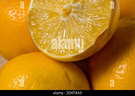 A close up of a lemon with the peel removed. The lemon is cut in half and the inside is visible Stock Photo