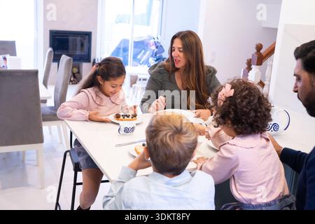 Family having breakfast with parents and children sitting around dining table Stock Photo