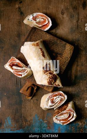 Smoked salmon on a wooden cutting board, garnished with herbs and ...