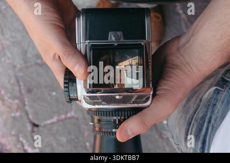 Hands holding vintage medium format camera viewing city Stock Photo