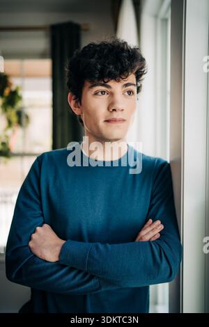 Young man with curly hair looking thoughtful Stock Photo