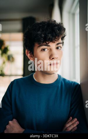Young man with curly hair looking at camera Stock Photo
