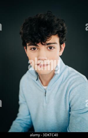 Young man with curly hair looking at camera Stock Photo