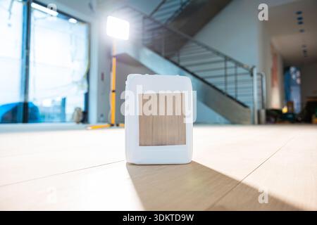 Contemporary indoor space featuring a staircase with metal railings, a bright light source near a glass window, and tools on a wooden floor. Stock Photo