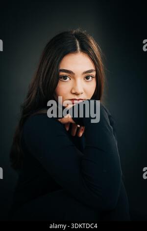 Young woman looking at camera with thoughtful expression Stock Photo