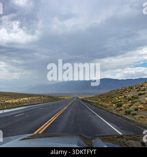 USA, Nevada, Winnemucca, Empty road and storm clouds seen from car Stock Photo