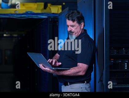 Man using laptop in data center Stock Photo