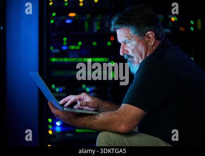 Man using laptop in data center Stock Photo