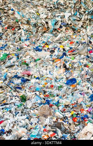 Large collection of plastic waste with bottles, wrappers, and debris in various colors and shapes, emphasizing the environmental impact of pollution. Stock Photo