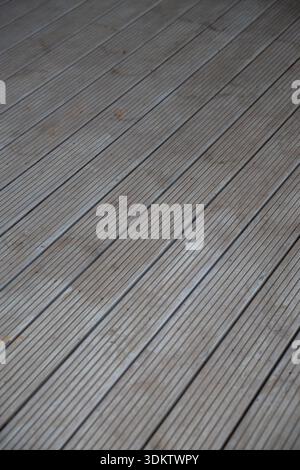 Horizontal wooden planks with visible grain patterns and subtle discoloration. The surface shows wear with small stains and textured grooves. Stock Photo